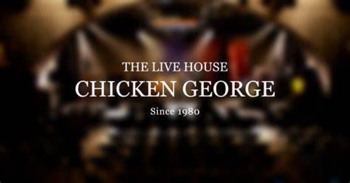 Chicken George looks at a cockerel