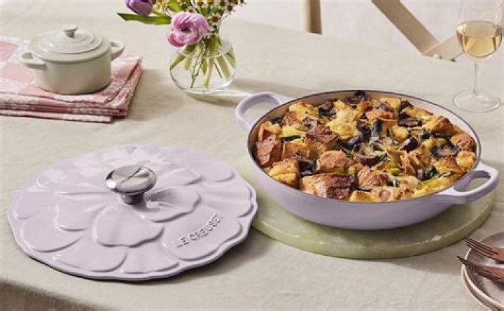 Le Creuset Signature Petal Braiser on table next to napkin and flowers