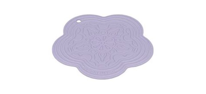 Purple Le Creuset Silicone Flower Trivet on white background